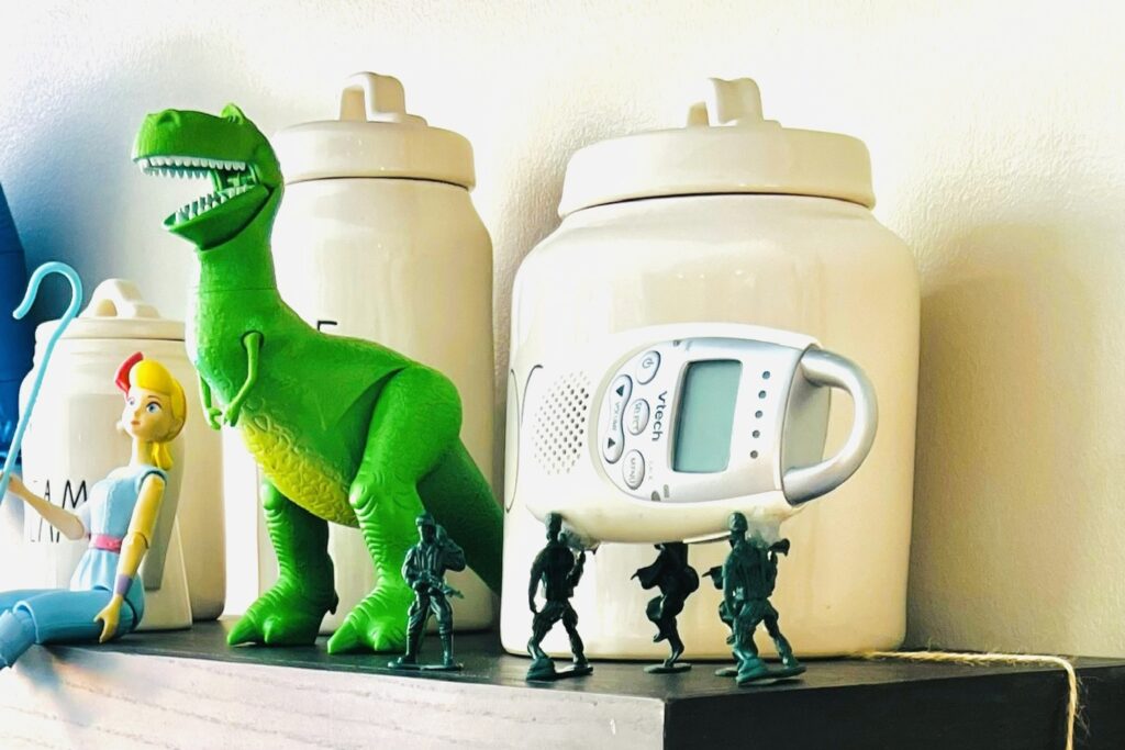 Army men toys with a baby monitor hot glued so they look like they are carrying it and other Toy Story toys in the background