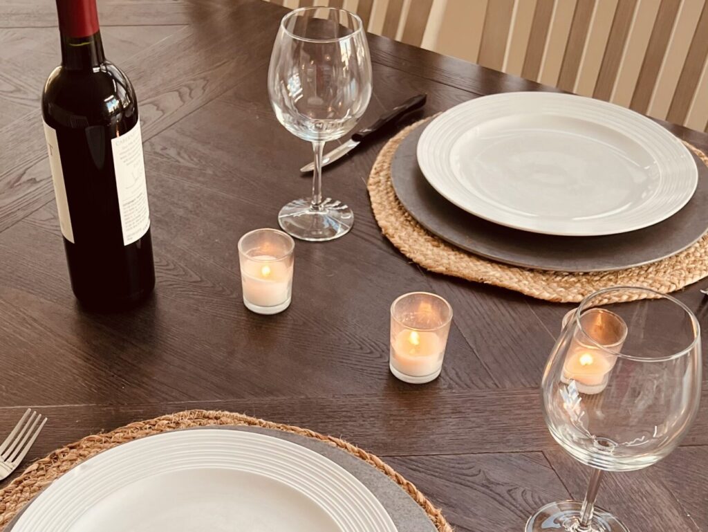 table set for two with plates, wine glasses and candles